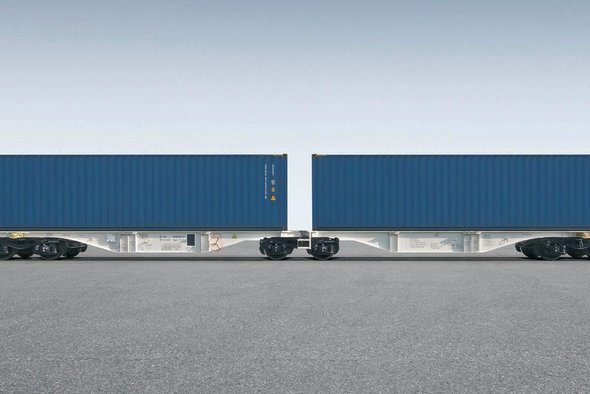 Grauer Containerwagen mit zwei blauen Containern darauf.