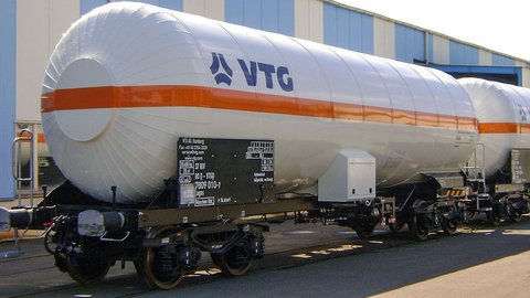 Weißer Flüssiggas-Kesselwagen mit orangem Streifen und blauem Logo.