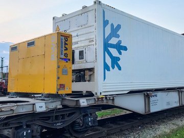 Gelbe Powerbox auf Intermodalwagen mit weißem Container