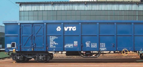 Blauer VTG-Boxwagen vor grauem Gebäude.