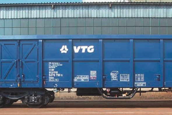 Blauer VTG-Boxwagen vor grauem Gebäude.