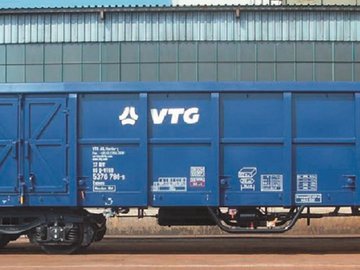 Blauer VTG-Boxwagen vor grauem Gebäude.