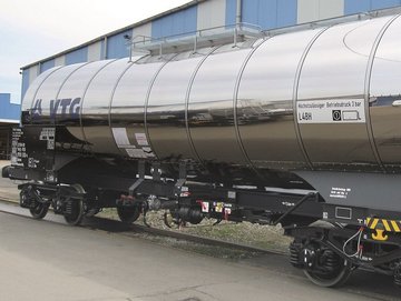 Silberner Chemie-Kesselwagen mit blauem VTG-Logo vor einer Halle.