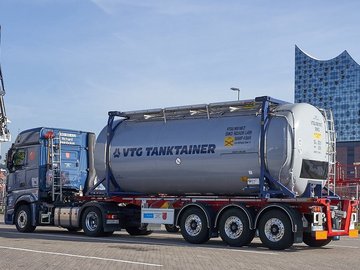 Grauer VTG-Tankcontainer auf einem blauem LKW vor der Elbphilarmonie in Hamburg.