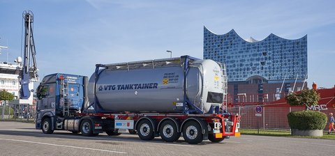 Grauer VTG-Tankcontainer auf einem blauem LKW vor der Elbphilarmonie in Hamburg.