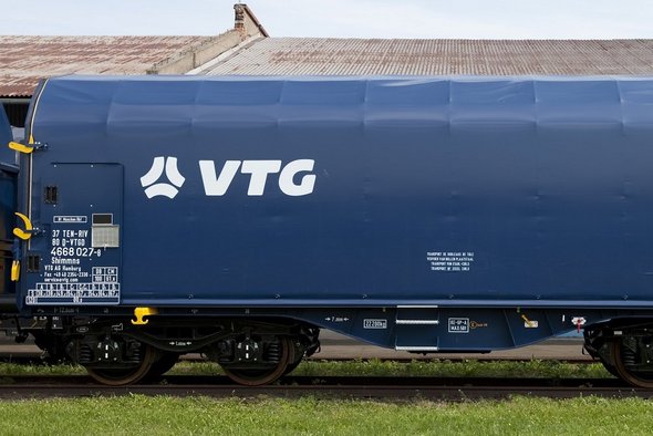 Blauer Flachwagen mit weißen VTG-Logo auf einer Schiene.