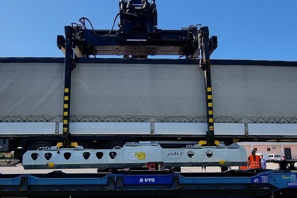 Container wird auf einen Wagon geladen.