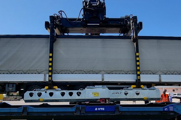Container wird auf einen Wagon geladen.