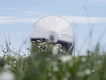 Silberner Kesselwagen mit Wiese im Vordergrund