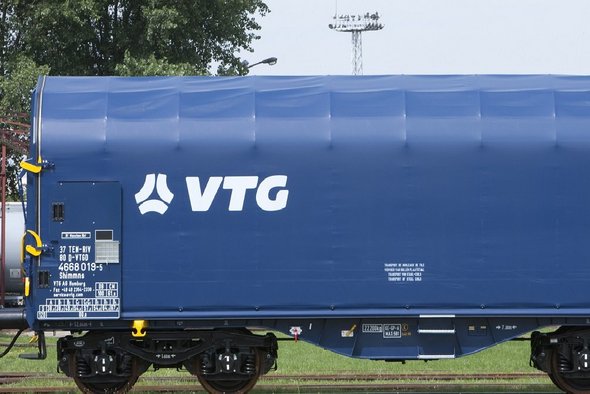 Blauer Flachwagen mit weißen VTG-Logo auf einer Schiene.