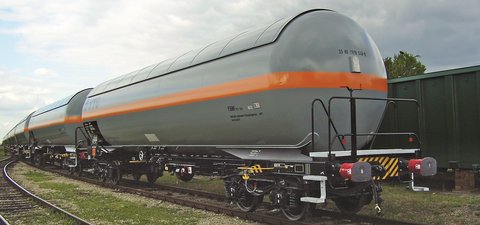 Aneinandergehängte weiße Flüssiggas-Kesselwagen mit orangem Streifen.